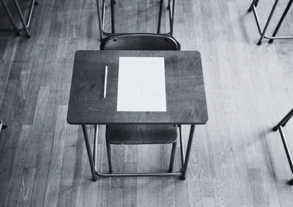 Table d'écolier avec une feuille vierge et un crayon