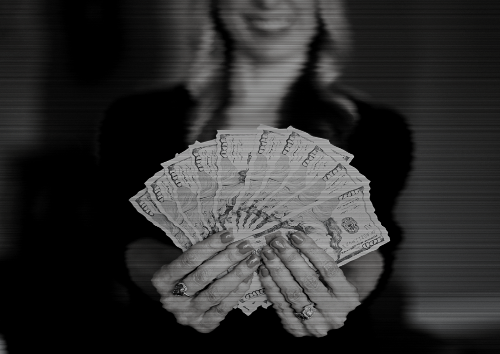 Femme souriante brandissant une poignée de billets