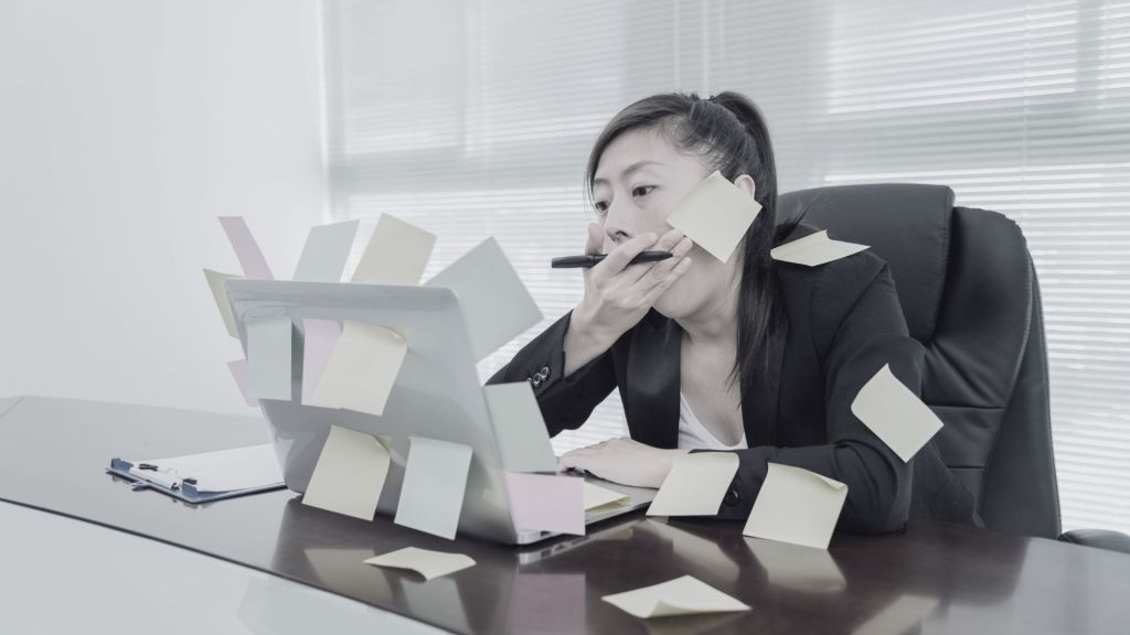 une personne baille devant son ordinateur recouvert d'une multitude de post it