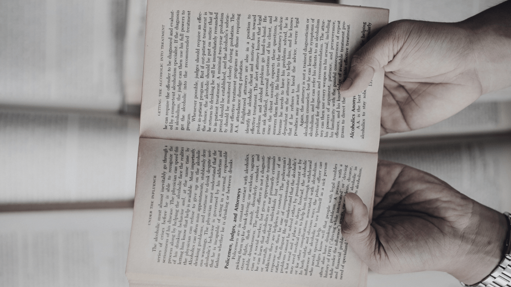 des mains tiennent un livre ouvert.