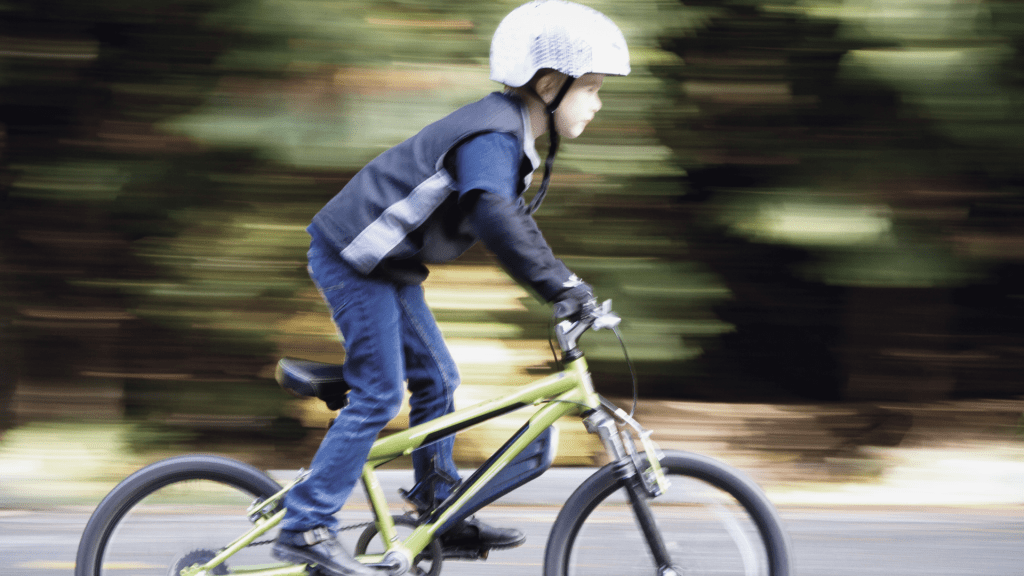 jeune garçon sur un vélo, l'arrière plan est flou, suggérant de la vitesse