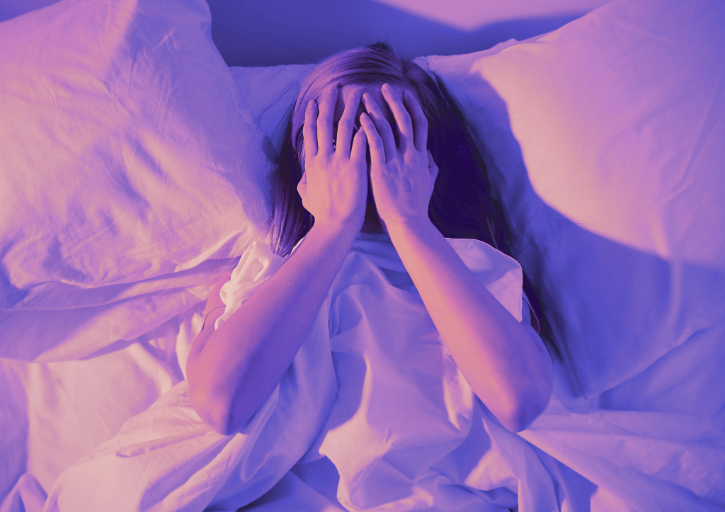 une personne dans un lit, les deux mains sur le visage