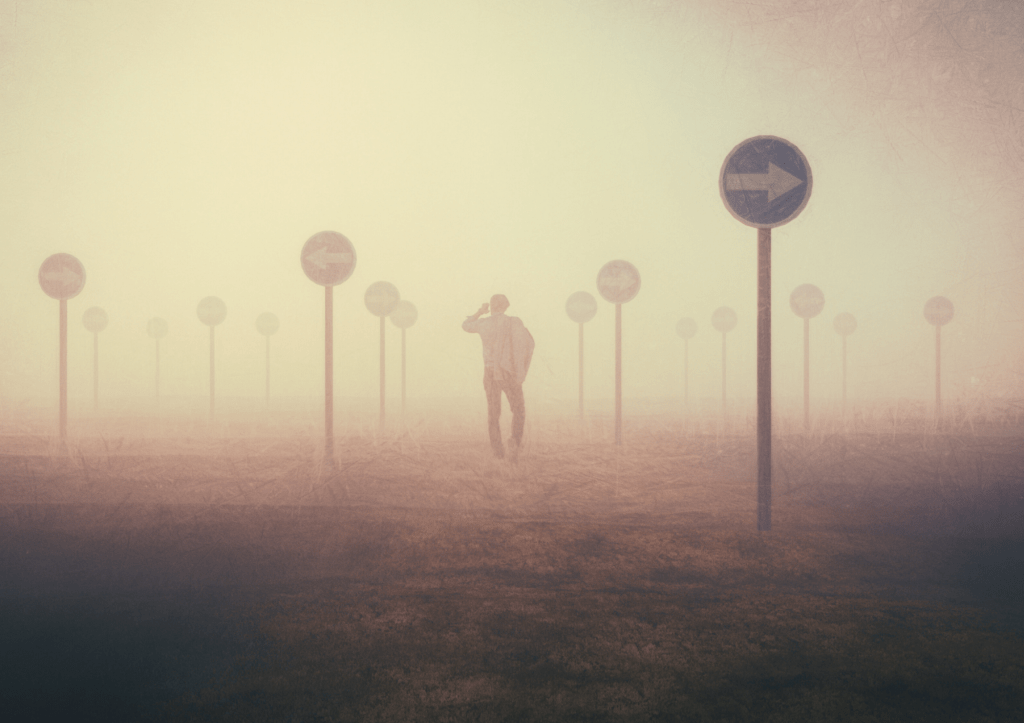 une personne perdue dans la brume au milieu de panneaux avec des flèches qui montrent des direction différentes
